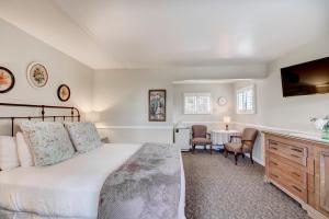 a bedroom with a bed and a table with chairs at Carmel Green Lantern Inn in Carmel