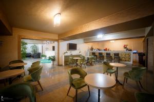 a restaurant with tables and chairs and a kitchen at Hotel Ozana in Bistriţa