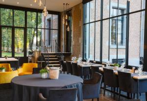 a restaurant with tables and chairs and large windows at Chateau Beausaint in La-Roche-en-Ardenne