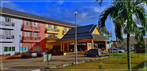 un edificio con coches estacionados en un estacionamiento en Hotel Seri Malaysia Sungai Petani en Sungai Petani