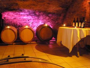 a table in a cellar with wine barrels at Holiday Home Weingut Mertes in Minheim