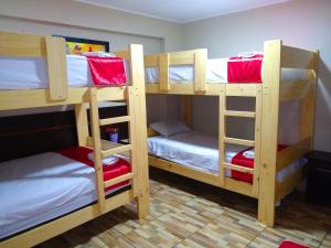 a bedroom with two bunk beds with red sheets at Imperio Tanpu Q in Lima