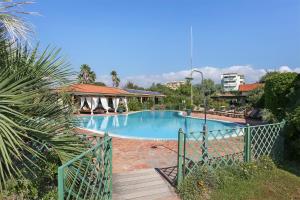 a large swimming pool in a resort with a wooden bridge at Soleado beach house in Pietrasanta