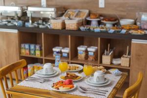 una mesa con platos de comida y vasos de zumo de naranja en Pousada Kanoas, en Maragogi