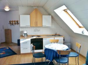 une cuisine avec une table et des chaises ainsi qu'une fenêtre dans l'établissement Ferienwohnung Blau, à Schweigen-Rechtenbach
