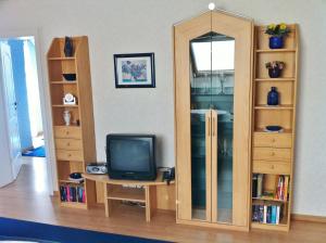 a living room with a tv and a mirror at Ferienwohnung Blau in Schweigen-Rechtenbach