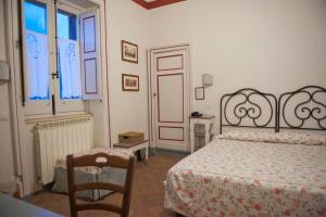 a bedroom with a bed and a chair and a window at Case Perrotta in SantʼAlfio