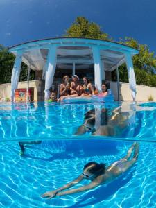 a group of people swimming in a swimming pool at Alonissos Muses Villas in Kalamakia