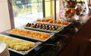 a buffet with three trays of food on a counter at Hotel Karawankenhof in Villach