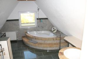 a bathroom with a tub with a window and a sink at Felsenkeller Coppenbrügge in Coppenbrügge