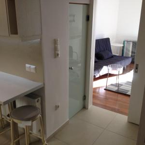 uma cozinha e uma sala de estar com uma mesa e um banco em Velvendou 36A Apartment em Atenas