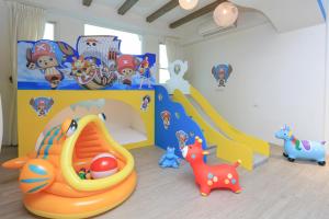 um quarto para crianças com uma área de recreação infantil com um equipamento de brincar em Chi Heng Homestay em Luodong