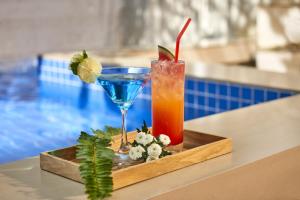 a drink on a tray next to a pool at The Wind Boutique Resort in Vung Tau