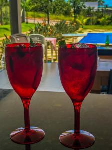 two red wine glasses sitting on top of a table at Casa Lago de Furnas in Capitólio