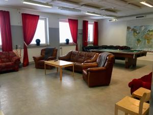 a living room with couches and a pool table at Hostel Finnmyrten in Juoksengi
