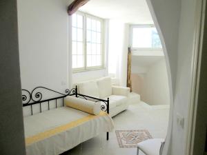 a living room with a white couch and a window at Sardinia Yellow House in Solanas