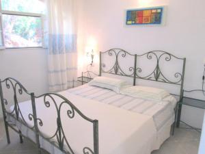 a bedroom with a metal bed in a room at Sardinia Yellow House in Solanas