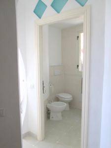 a bathroom with a toilet and a blue ceiling at Sardinia Yellow House in Solanas