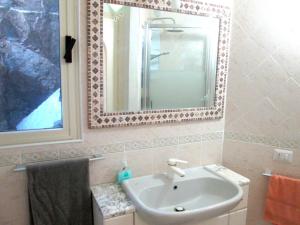 a bathroom with a sink and a mirror at Sardinia Yellow House in Solanas