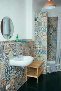 a bathroom with a sink and tiles on the wall at Hostel & Garten Eden in Leipzig