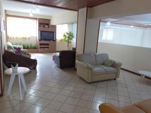 a living room with two chairs and a tv at Ilhamar Canas Hotel in Florianópolis