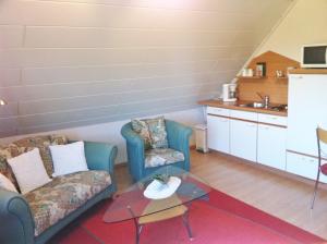 a living room with two chairs and a coffee table at Ferienwohnung Grün in Schweigen-Rechtenbach