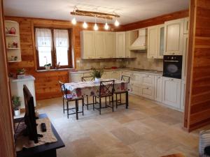 - une cuisine avec des placards blancs, une table et des chaises dans l'établissement Appartamento L'albero e le stelle, à Borgo San Dalmazzo