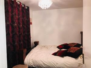 a bedroom with a bed and a red curtain at Modern cosy room with private bathroom in Harrow