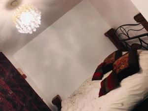 a bedroom with a bed and a chandelier at Modern cosy room with private bathroom in Harrow