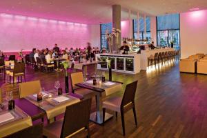 a restaurant with people sitting at tables and a bar at INNSiDE by Meliá Düsseldorf Derendorf in Düsseldorf