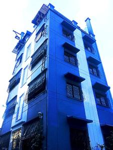 een hoog blauw gebouw met veel ramen bij Las Pinas Serviced Apartment in Manilla