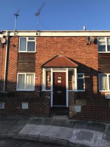 a red brick house with a black door at Modern cosy room with private bathroom in Harrow