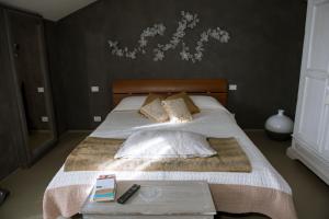 Schlafzimmer mit einem Bett mit weißer Bettwäsche und Kissen in der Unterkunft "Nido del Falco" Palazzo Ricotti in Camerano