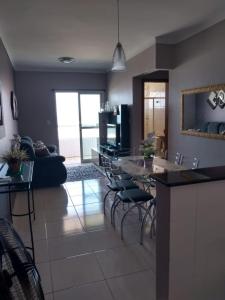 a kitchen and living room with a table and chairs at VILA CAIÇARA-FRENTE P/MAR in Solemar