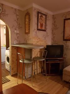 a living room with a bar with stools and a television at House Hotel Apartments 3 in Rivne