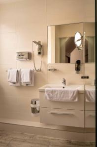 y baño con lavabo y espejo. en Hotel Anker en Klosterneuburg