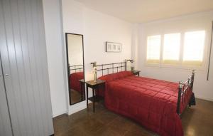 ein Schlafzimmer mit einem roten Bett und einem Spiegel in der Unterkunft Duplex en frente de la playa al lado de Barcelona in Canet de Mar