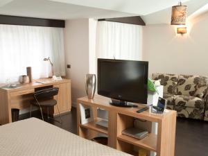 Televízia a/alebo spoločenská miestnosť v ubytovaní Hotel Bruman