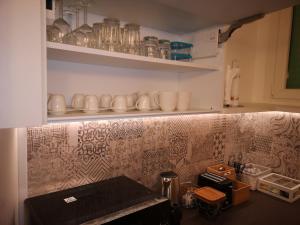 a kitchen with cups and dishes on a wall at 2 Navigli in Milan