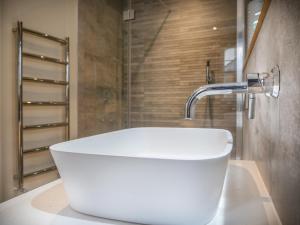 a white sink in a bathroom with a shower at Padstow Escapes - The Long Room Luxury Apartment in Padstow