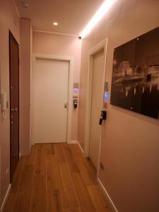 a hallway with a white door and a painting on the wall at 2 Navigli in Milan