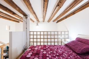 a bedroom with a purple bed and wooden ceilings at RIPAMONTI 22 in Milan