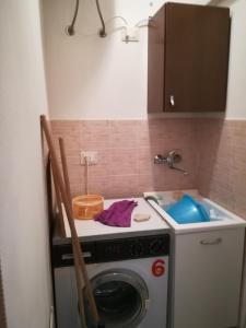 a kitchen with a washing machine and a sink at Delle Zagare Apartments in Alcamo Marina