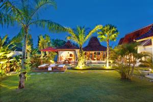 an exterior view of a house with palm trees at Villa Nico - Private Pool with Onsite Spa in Canggu