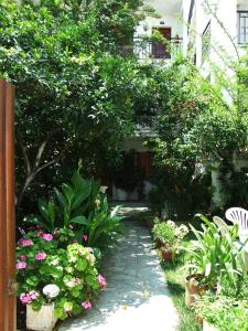 a garden with flowers and plants on a path at Fotinos House Skiathos in Skiathos