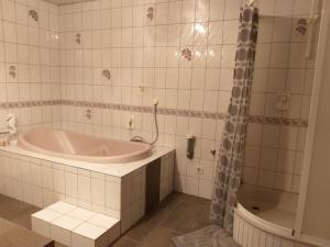a white bathroom with a tub and a shower at Appartment in Rechberghausen