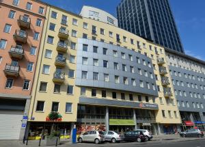 a yellow building with cars parked in front of it at Chopin Apartments - Eco in Warsaw