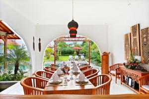 a dining room with a long table and chairs at Villa Nico in Canggu