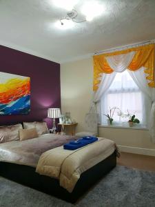 a bedroom with a bed with a painting on the wall at Gabriel Guesthouse in Rhyl