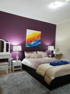 a purple bedroom with a bed and a purple wall at Gabriel Guesthouse in Rhyl